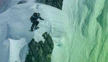 A person snowboarding off a mountain