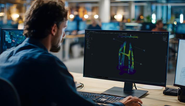 Image showing a man working on a computer with Onshape Simulation on the screen.