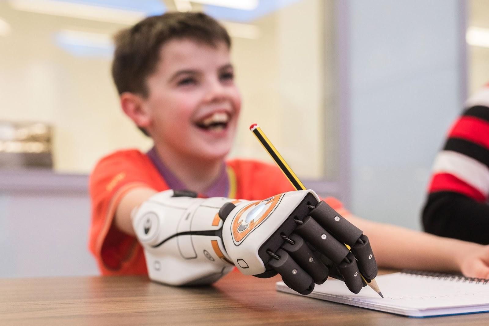 Image showing a child writing with a prosthetic developed by Tatum Robotics.