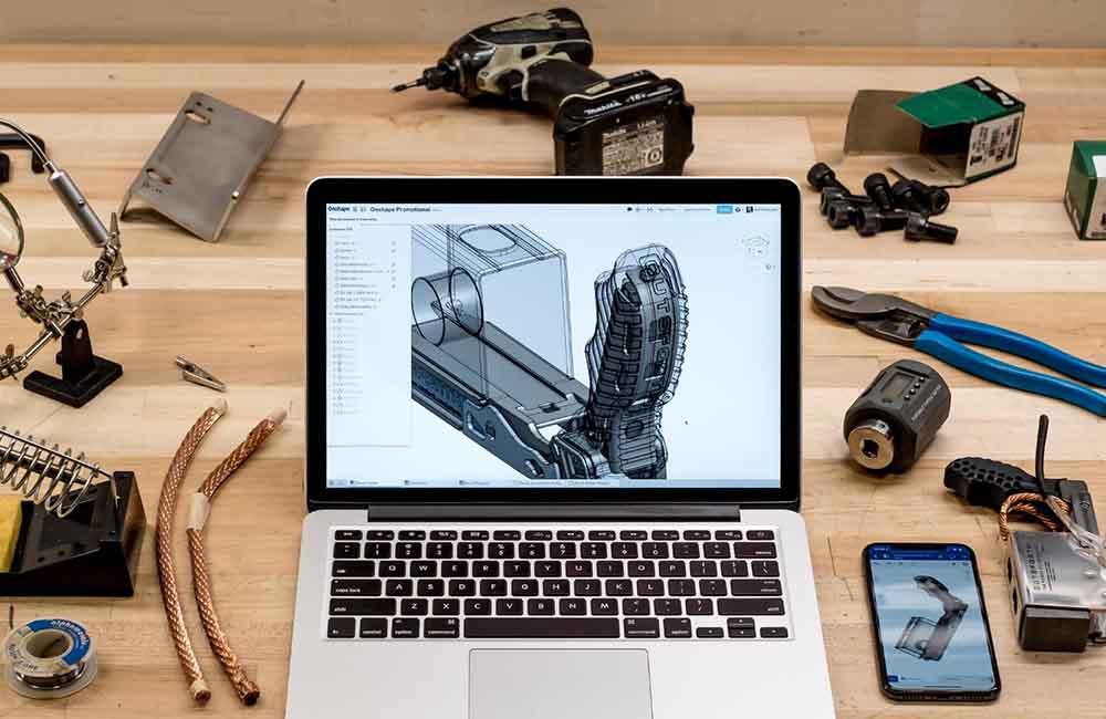 laptop surrounded by tools.