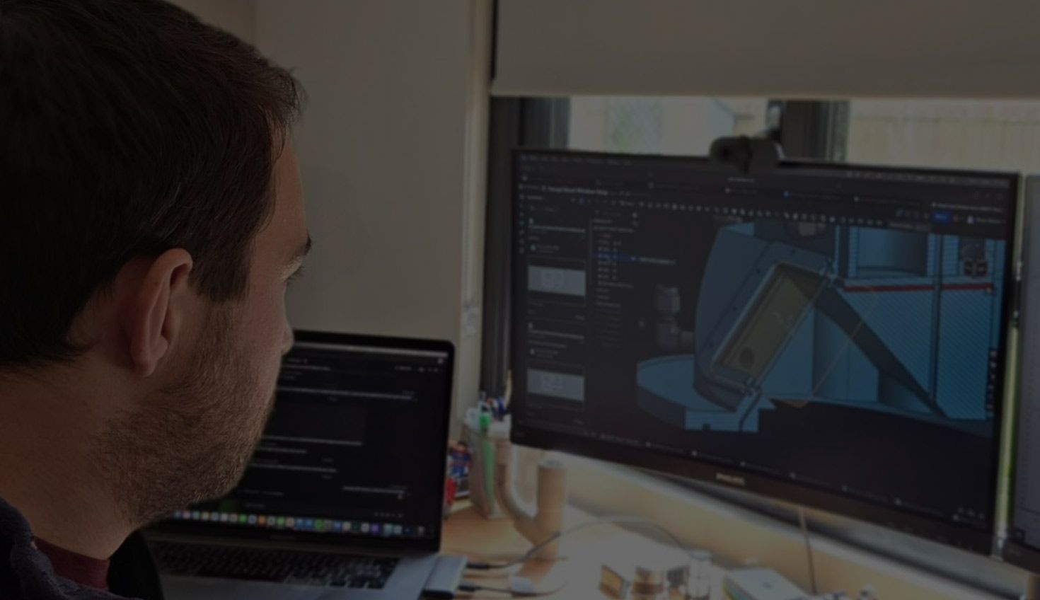 An engineer looks at a CAD drawing on a computer screen.