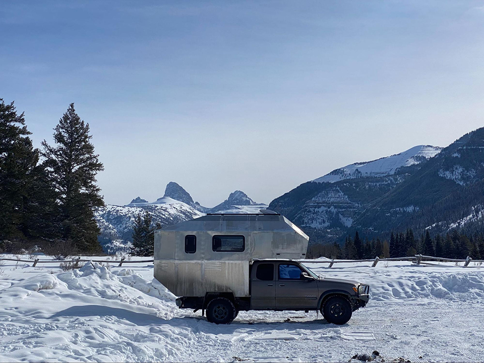 The camper in front of snow-capped Tetons.