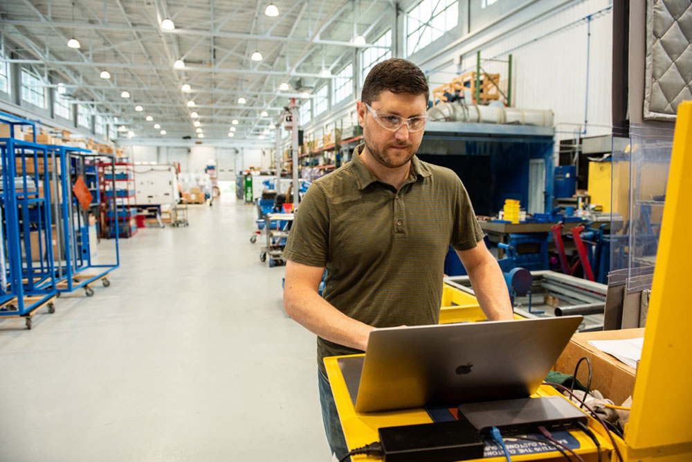 A shop floor worker using a Mac.